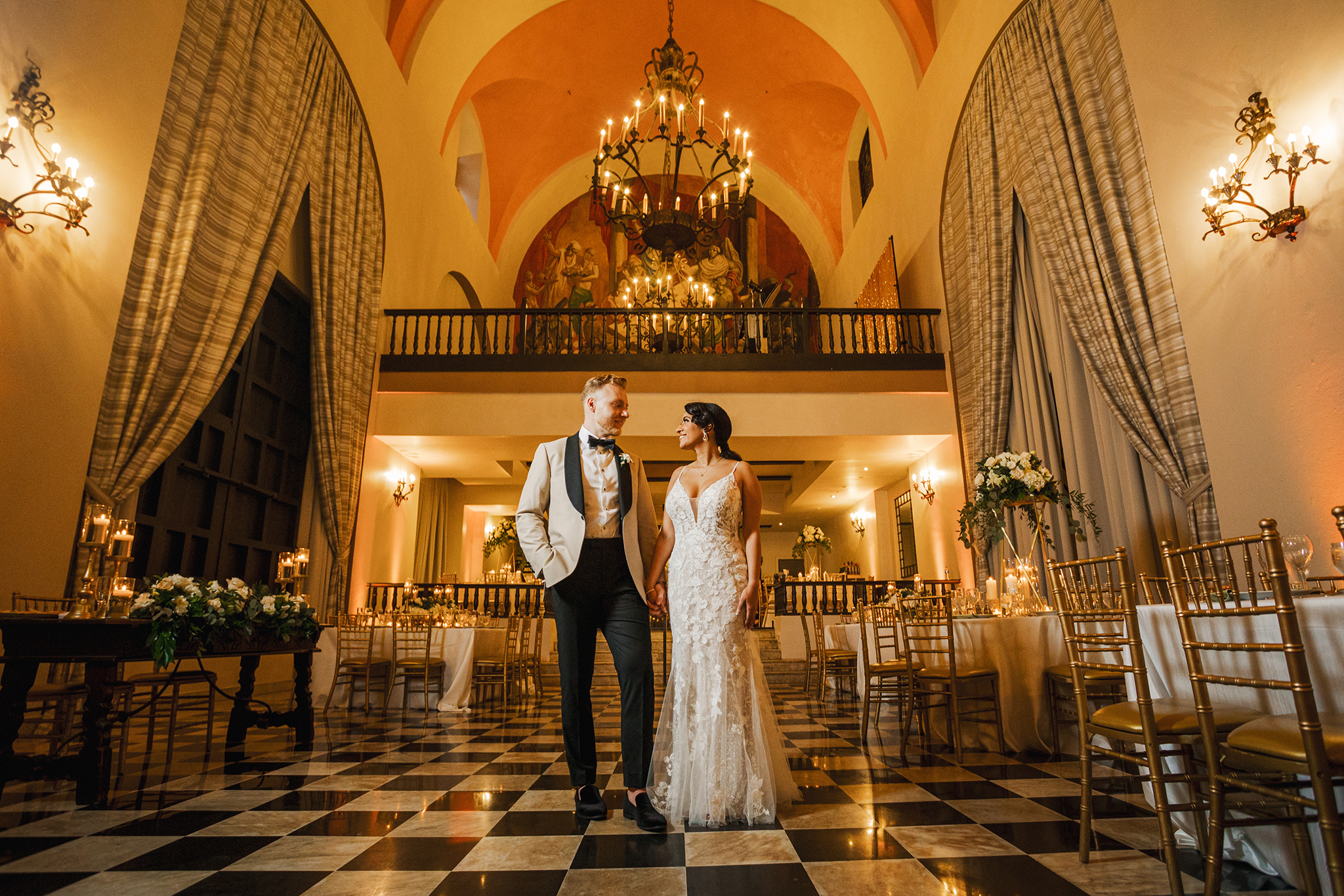 A destination wedding couple standing in an ornate room.